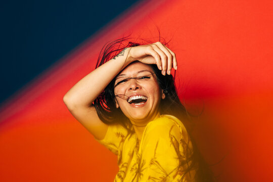 Gorgeous mixed race woman smiling over red background