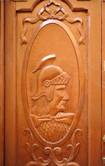 Puerta de madera con soldados romanos de perfil en Cáceres, Extremadura, España