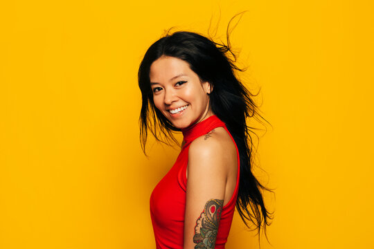 Gorgeous mixed race woman smiling over yellow background