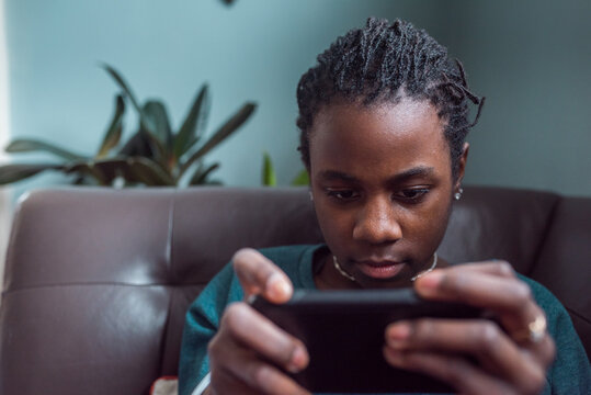 Portrait of a black girl playing games on her mobile device