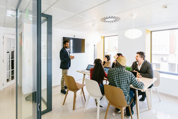 Man presenting speech in front of colleagues in office