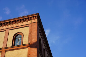 Teilansicht eines alten Backsteingebäudes in der Maxvorstadt in München bei blauem Himmel 