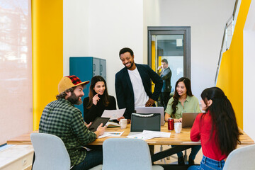 Modern smiling people at table working on project