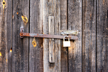 old wooden gate with bolt and padlock