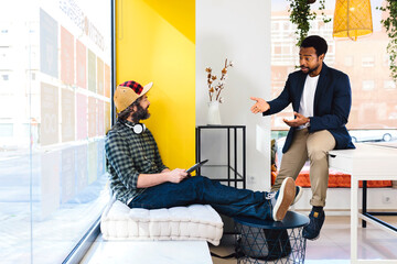 Diverse male colleagues chatting in modern office