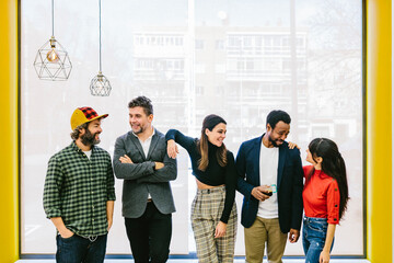 Smiling diverse friendly coworkers standing in row