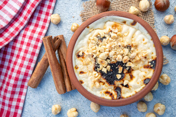 Baked rice pudding turkish milky dessert sutlac in earthenware casserole with hazelnuts