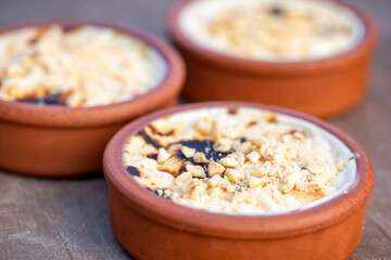 Baked rice pudding turkish milky dessert sutlac in earthenware casserole with hazelnuts