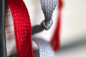 Knoten in einem grauen Bändchen eines kirchlichen Gesangbuchs in einer katholischen Kapelle