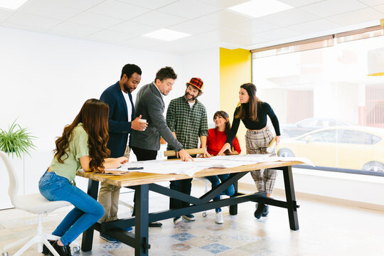 Stylish and creative colleagues at desk in office