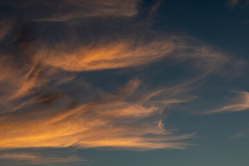 Sunset colorful epic colorful golden clouds on blue dark vivid sky. Magic dusk epic cloudscape