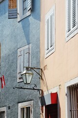 Fototapeta na wymiar Colorful walls with a wooden windows and an old lantern in an ancient city of Budva, Montenegro