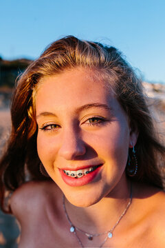 Portrait of happy beautiful teen girl at the beach with brackets