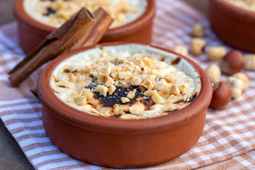 Baked rice pudding turkish milky dessert sutlac in earthenware casserole with hazelnuts