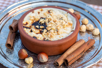 Baked rice pudding turkish milky dessert sutlac in earthenware casserole with hazelnuts