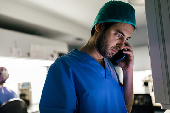 IVF Biologist on phone while manipulating an incubator