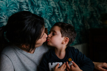 Mother and son having fun while using a computer at night