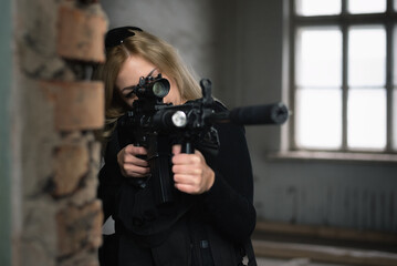 A woman soldier with airsoft rifle is aiming. Special force concept.