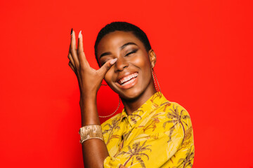 Beautiful Afro Woman posing over red crying of laughter background smiling with eyes closed