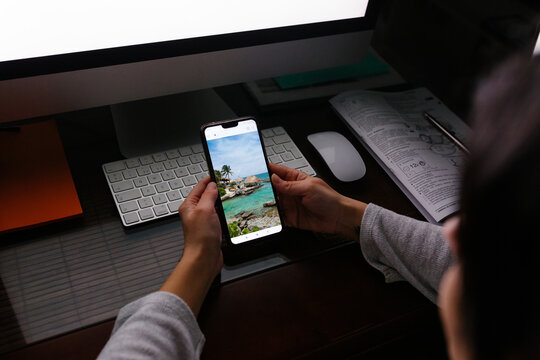 Anonymous woman telecommuting at home while looking at vacation