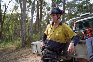 Arborist leaning against work truck
