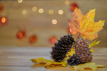 Cozy autumn conceptual still life with cones and maple leaves