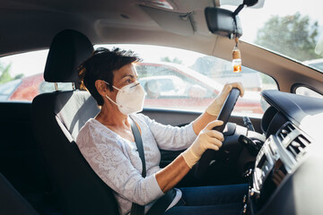 Senior woman driving car with mask