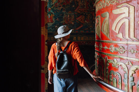 Woman spinning a big prayer wheel