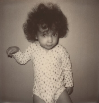 Polaroid black and white photo of kid looking at camera