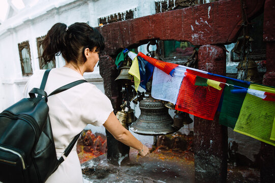 Woman near Boudhanath Stupa ringing in a bell