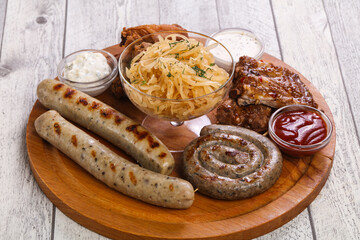 Meat plate with grilled sausages, ribs and chicken wings
