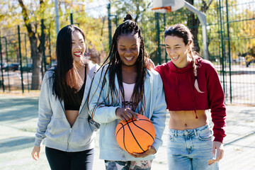 Multi ethnic group of friends with basketball ball hanging out