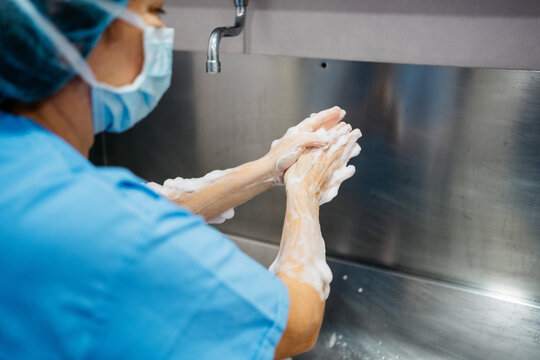 Surgeon washing her hands before going to the operating room - Powered by Adobe