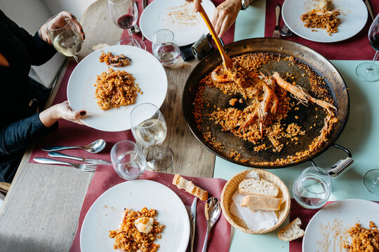 Family dinner with seafood paella and wine