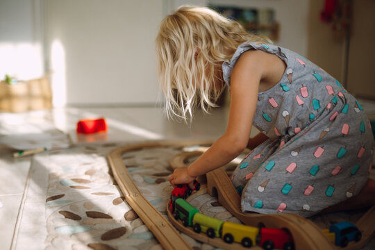 Little girl plays with a train set