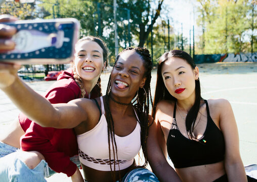 Three women friends taking a selfie - Powered by Adobe