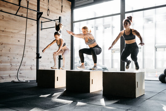 Group of women box jumping during a crossfit training