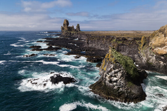 Waves from the arctic sea crash agains black cliffs in Iceland