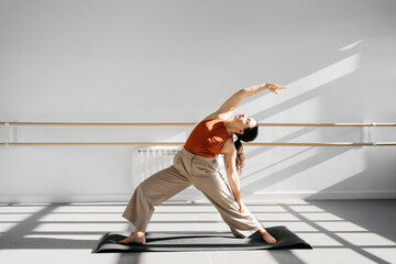 Young active woman doing yoga in a sunny studio