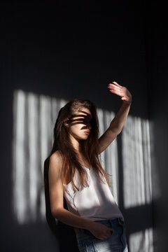 Young woman closes her hand from the light