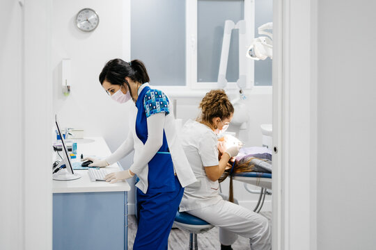 Dentist using computer during intervention