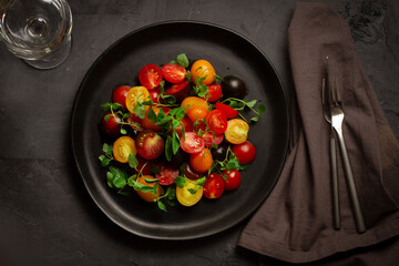 cherry tomato salad, on a black background, top view 