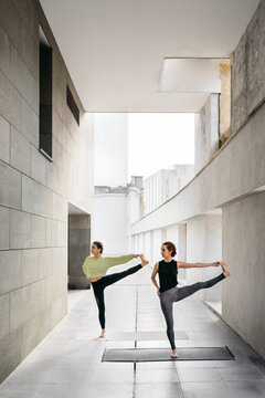 Young women doing eka pada jathara parivartanasana yoga pose