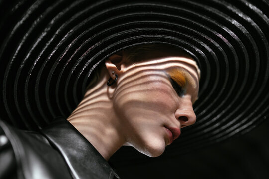 fashion shot of a girl in a wide-brimmed hat with beautiful shadows on her face