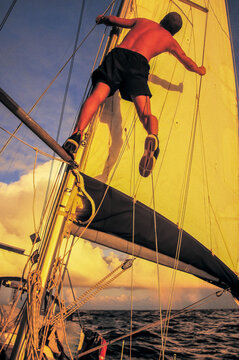 a sailor is checking his sails at sea