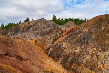 Unusually beautiful autumn landscape of red lakes, colorful slopes and forest. Ural Mars. Ripples of dark red water on the surface of a lifeless lake Grey clouds moving in the overcast sky.