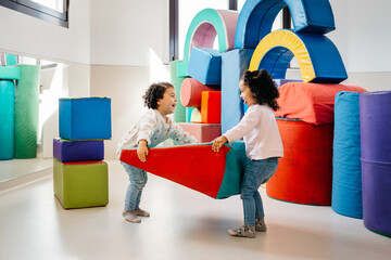 Happy ethnic girls building castle