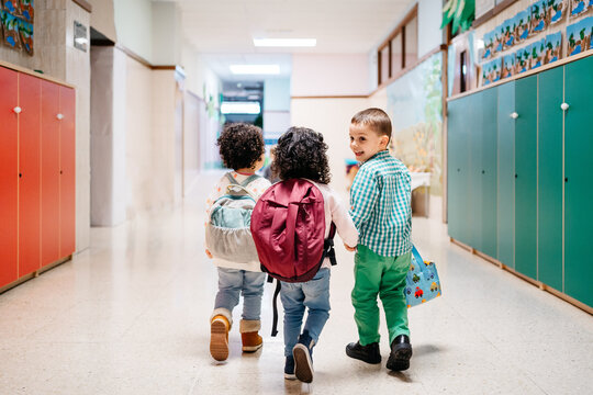 Happy kids walking in school corridor