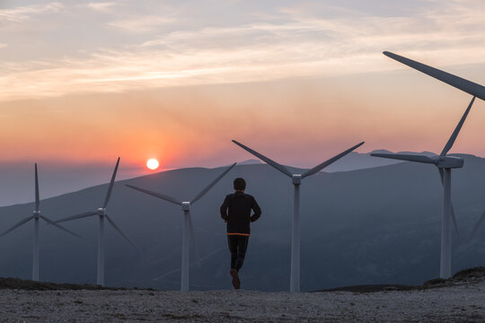 man running towards wind generators