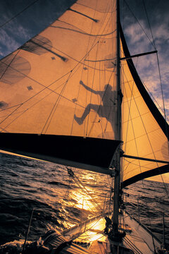 The shadow of a sailor is checking his sails at sea